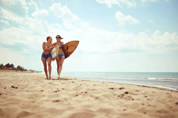 Kamarádkám, kteří jdou surfovat. Zdravý aktivní životní styl — Stock fotografie