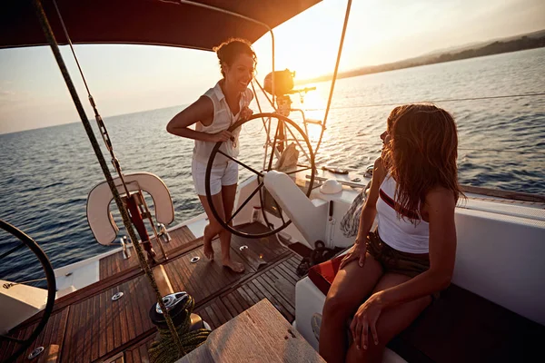 Mulheres jovens navegando no barco de luxo juntos e desfrutar de sunet — Fotografia de Stock