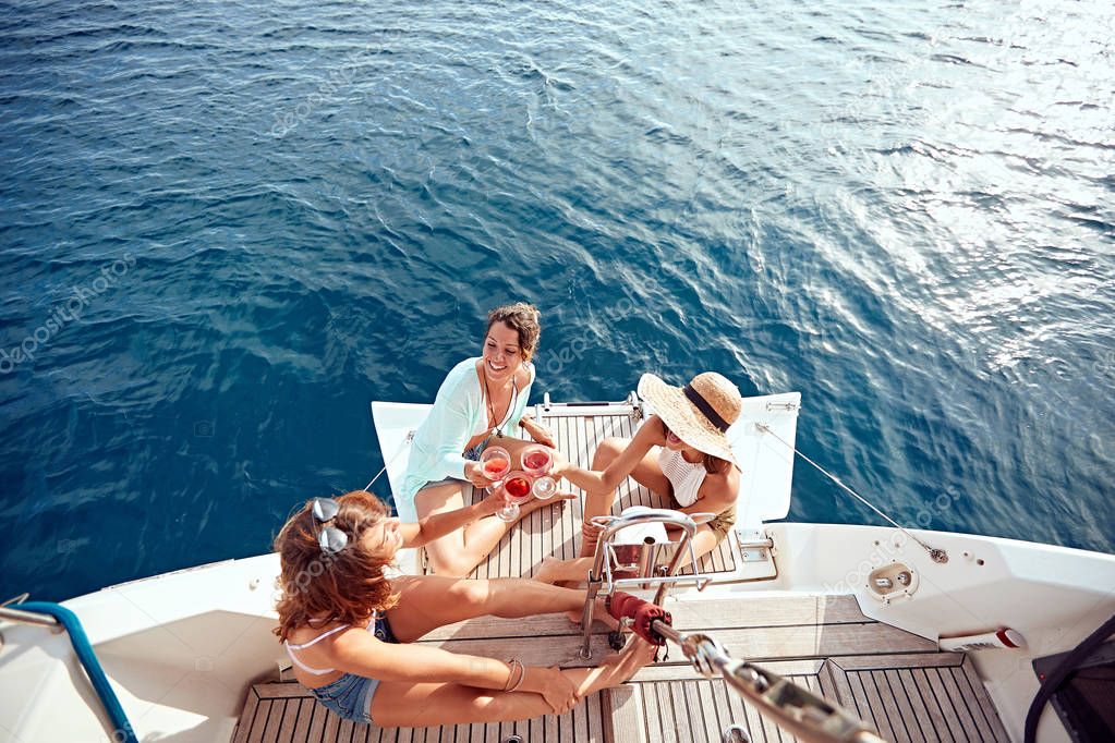 friends girl having party on sailing boat and drinking wine top view