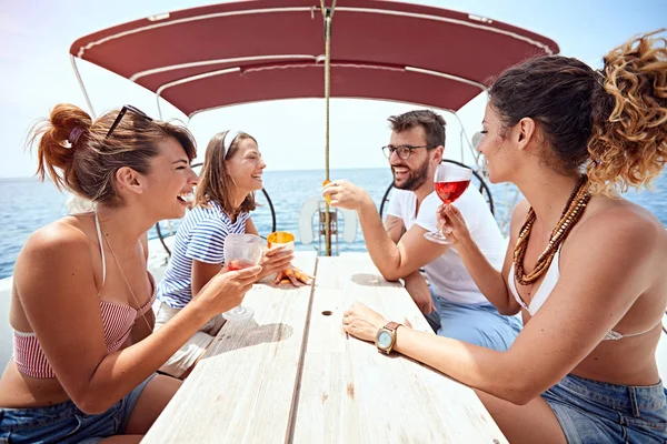 Kamarádi opékáte nápoje na palubě jachty a smějí se — Stock fotografie