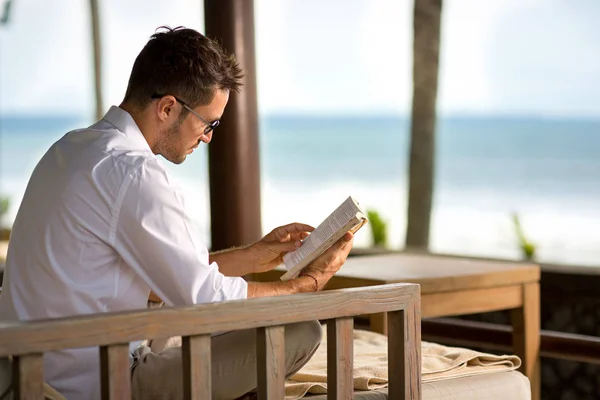 Jovem relaxante e livro de leitura — Fotografia de Stock