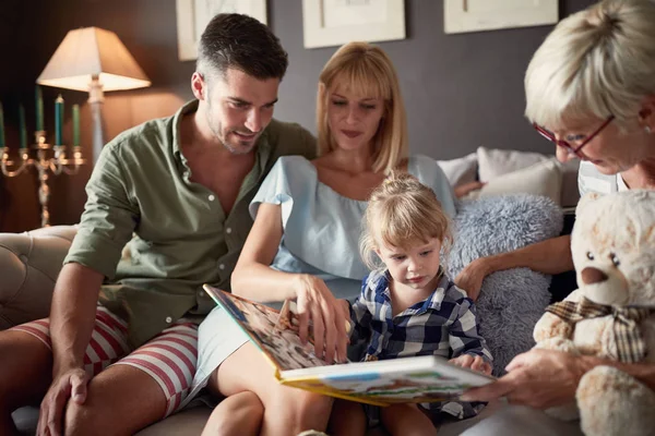 Familj ser bilderbok med barn — Stockfoto