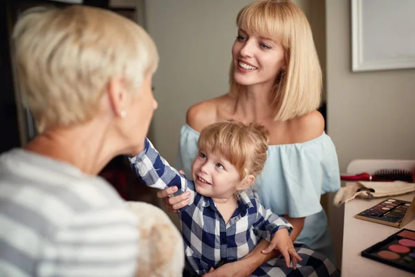 Little  girl putting makeup on face to her grandma — Stock Photo, Image