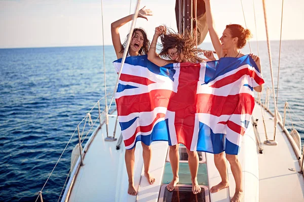 Meninas no iate em bandeira americana tendo festa - férias, viagens, mar, amizade e conceito de pessoas — Fotografia de Stock