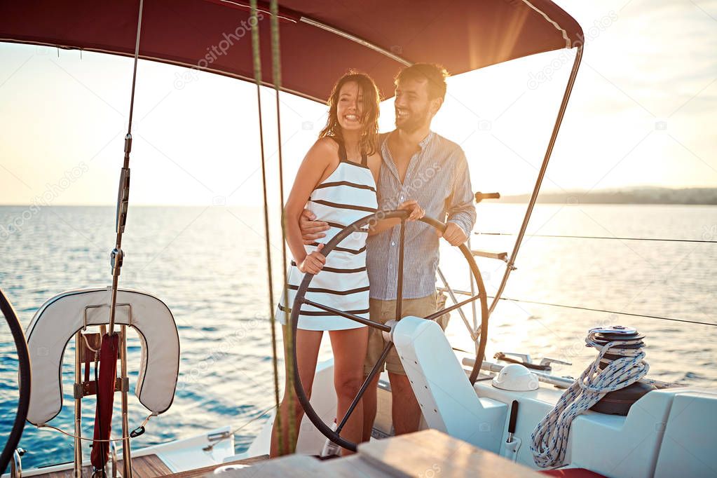 Romantic couple on boat together enjoy at sunset on vacation