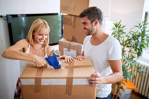 Casal de mudança para novo apartamento e descompactar boxe — Fotografia de Stock