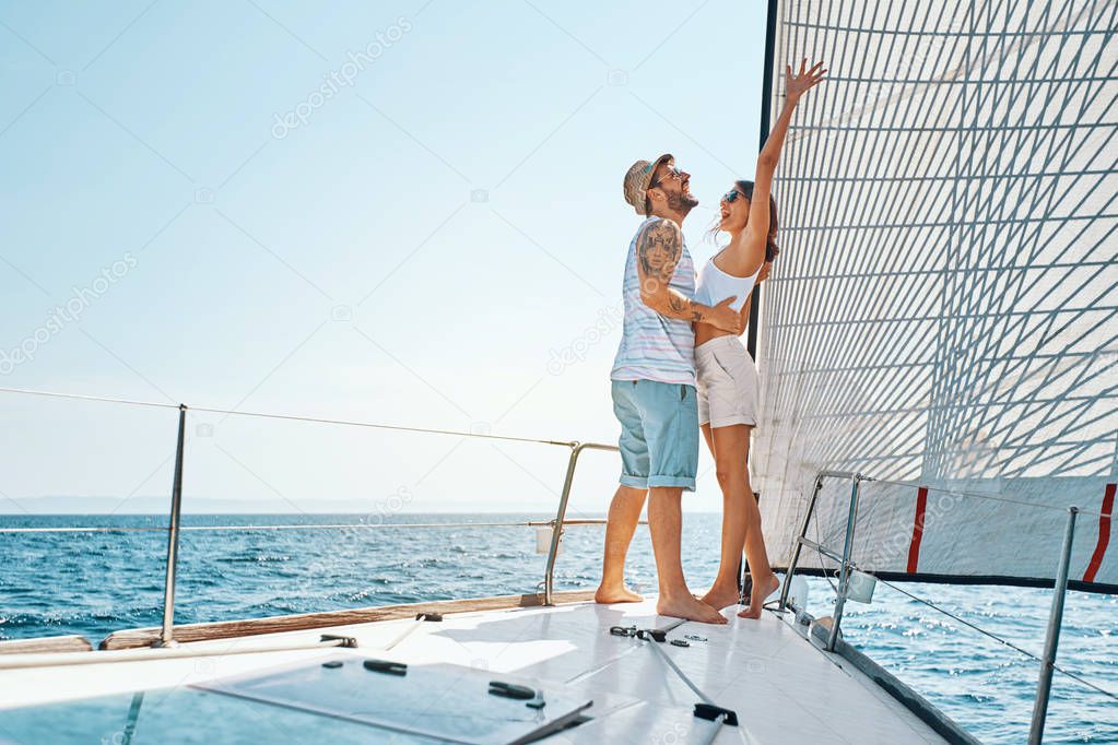 Smiling lovers traveling on vacation sailing on open sea ocean enjoying romance