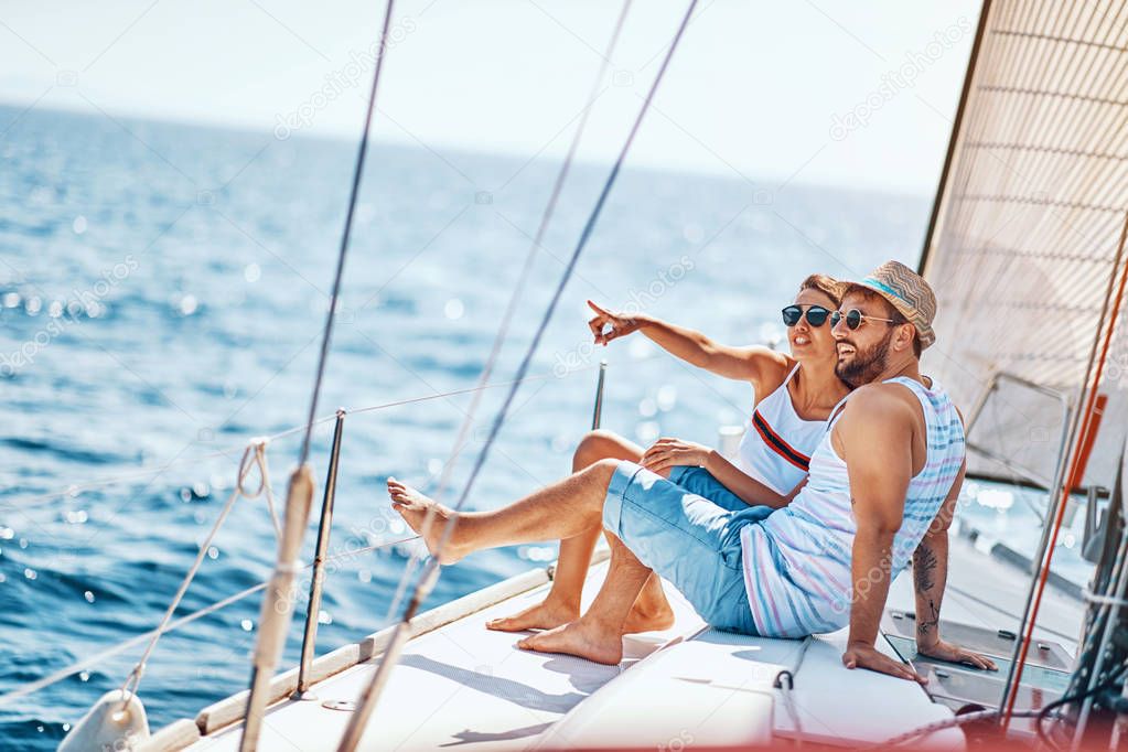 Romantic man and woman spending time together and relaxing on yacht