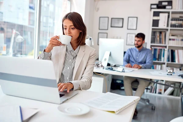 ビジネスウーマンは職場でコーヒーを飲む — ストック写真