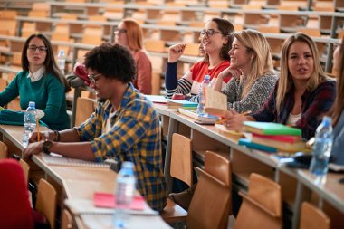 oditoryumda üniversitede birlikte vakit geçiren öğrenciler