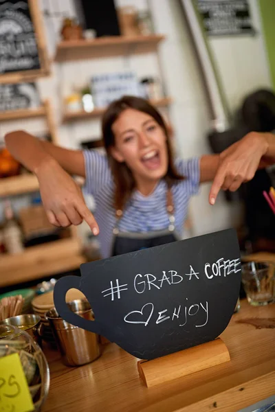 Kvinna ägare med Grab skylt för kaffe — Stockfoto