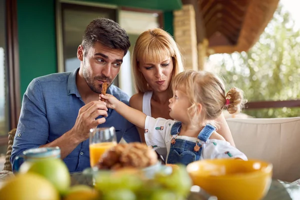 Adorable child feeds her dad — Stock Photo, Image