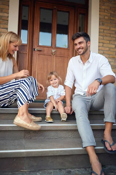 Ragazza con giovani genitori seduti sulle scale — Foto Stock