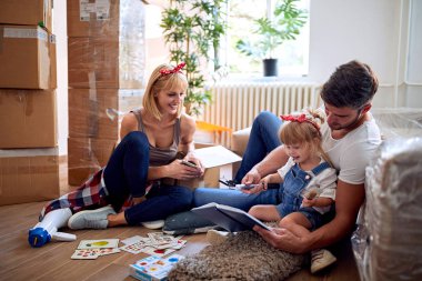 Yeni evde hareket eden bir bebek kız ile erkek ve kadın