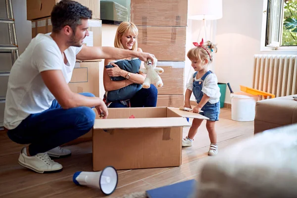 Junge Familie nach dem Kauf eines neuen Hauses packt Kiste aus — Stockfoto