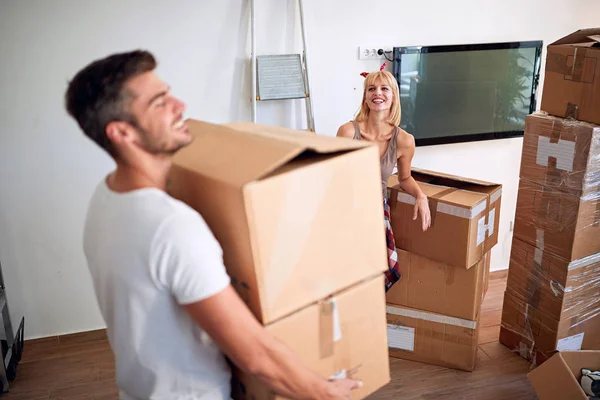 Couple carrying boxes and moving into a new home, having fun — Stock Photo, Image