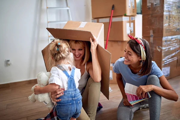 Feliz hija y madres gays en nuevo hogar familiar — Foto de Stock