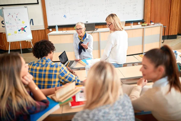 Unga studenter som lyssnar på föreläsare i klassrummet — Stockfoto