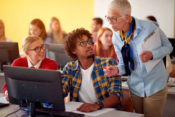 Docente di informatica in classe assistendo studente universitario — Foto Stock