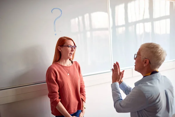 Professor explaining and questioning student in classroom on board — Stock Photo, Image
