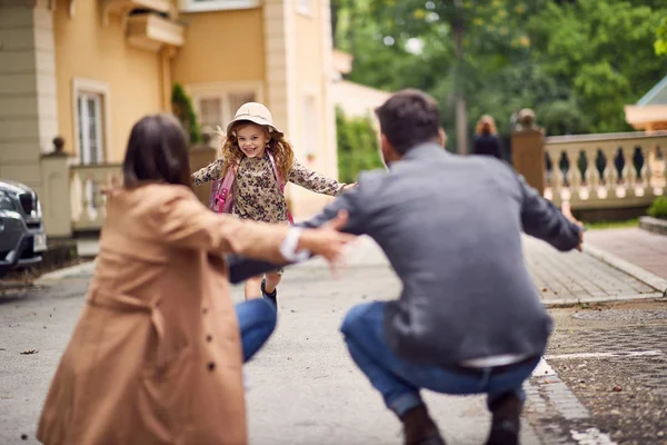 First day of school is over, happy parents waitnig on a schoolgi — Stock Photo, Image