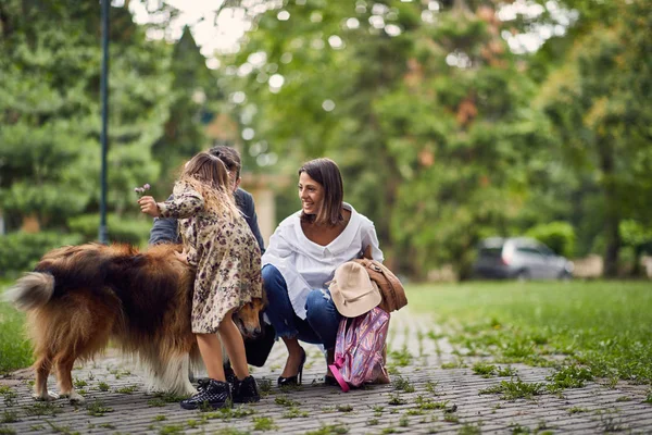 Beautiful happy family is having fun with Rough Collie outdoors. — Stock Photo, Image
