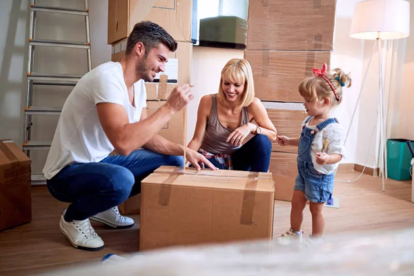 family after buying new house unpacking boxes