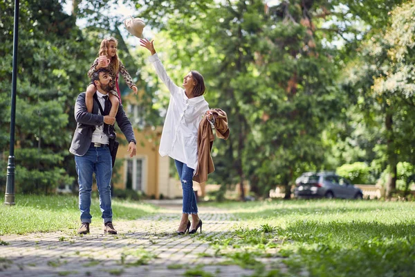 Padres jugando con su hija en la naturaleza después de la escuela — Foto de Stock