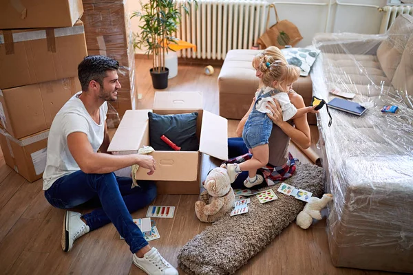 Föräldrar och dotter, packa lådor och flytta in i ett nytt hem — Stockfoto