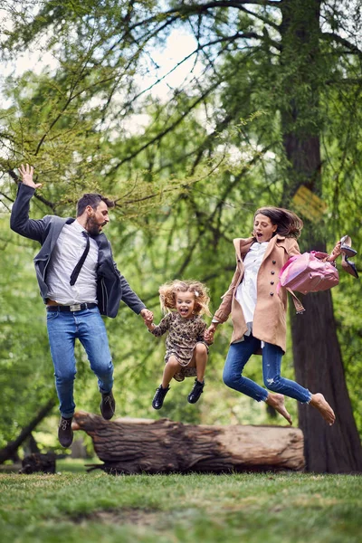 Heureux saut en famille dans le parc après l'école et le travail — Photo