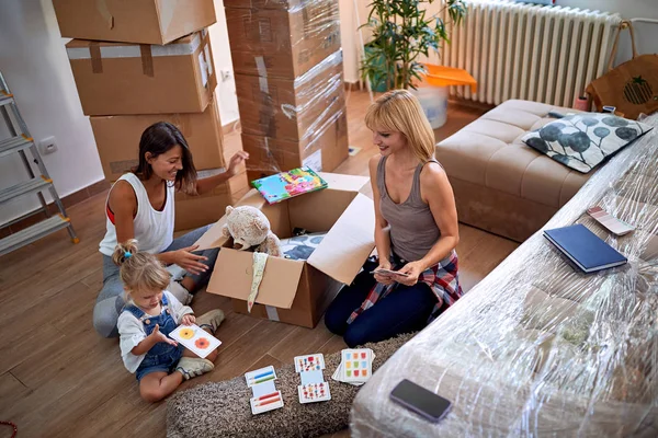 Gay mothers with a toddler girl moving in new home — Stock Photo, Image