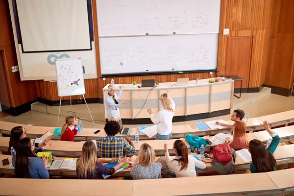 Grupp studenter som lyssnar på föreläsare i klassrummet — Stockfoto