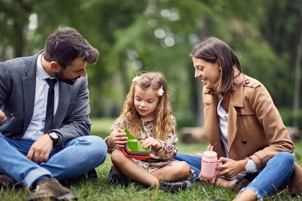 Lächelnde Eltern, die Spaß mit der kleinen Schülerin haben — Stockfoto