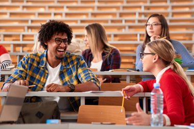 Üniversite campu'nda birlikte okuyan gülümseyen arkadaşlar
