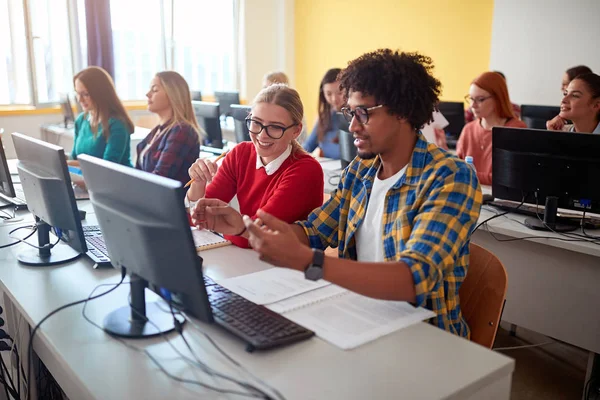 Un üzerinde sınıfta bilgisayar kullanarak masada birlikte oturan öğrenciler — Stok fotoğraf