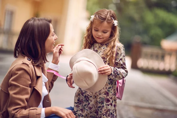 Nette kleine Schülerin nach dem Unterricht im Freien mit ihrer Mutter — Stockfoto