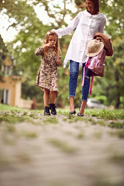 Maminka a školní dívka jdou domů ze školy — Stock fotografie