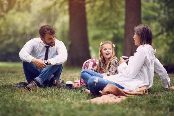 Ung familj efter arbete och skolsittning och vila på Park — Stockfoto