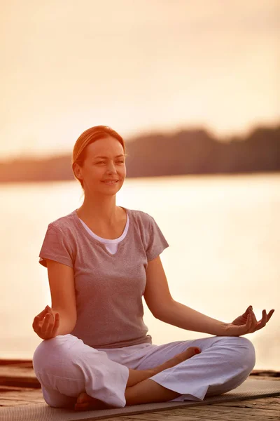 Frauen praktizieren Yoga in Flussnähe — Stockfoto