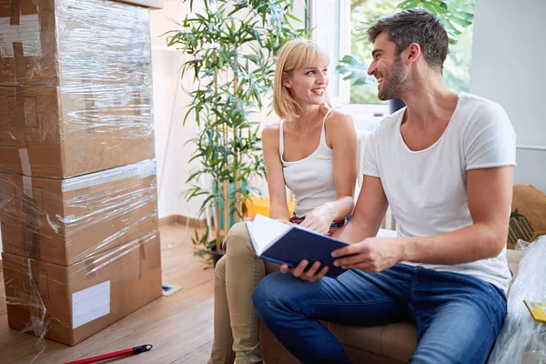 Man and woman packing boxes while moving hous — Stock Photo, Image