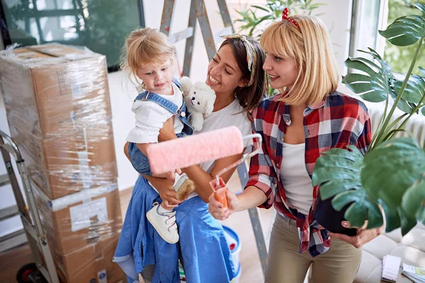 Lesbische ouders met dozen-paar verhuizen naar een nieuw huis met — Stockfoto