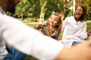parkta okuldan sonra anne ve babaları ile birlikte oynayan çocuk kız