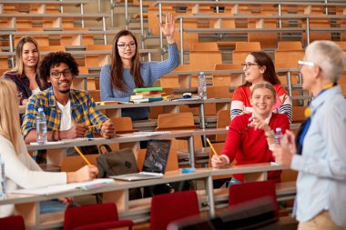 Öğrenciler derste soruya cevap vermek için el kaldıran 