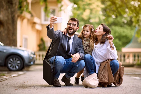 Pupil girl and parents after first day of school is over making a photo — Stock Photo, Image