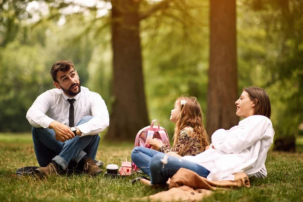 Mor och far med sin dotter efter jobbet och skolsittning och vila på Park — Stockfoto