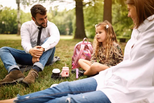 Filha com seus pais sentados e descansando no parque — Fotografia de Stock