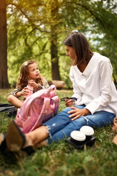 Filha com a mãe sentada e descansando no parque — Fotografia de Stock