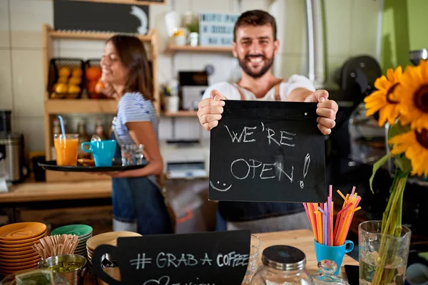 Genç adam barista açık işaret gösteren