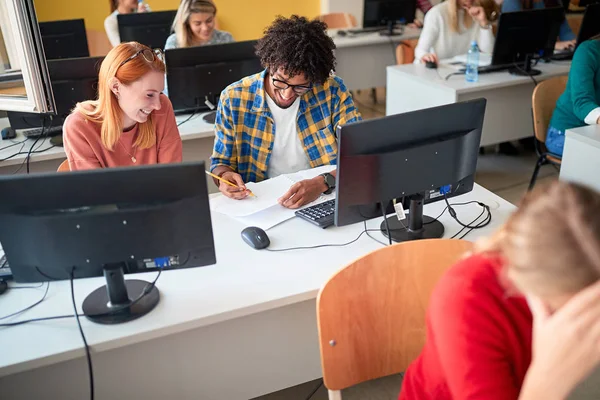 Sorrindo estudantes diversos em um exame em uma sala de aula — Fotografia de Stock