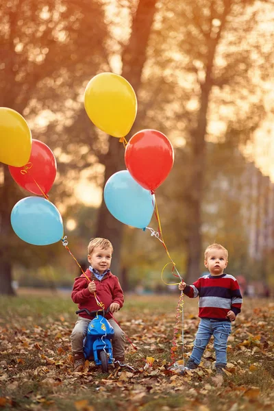 Bambini che giocano nel parco autunnale con palloncini — Foto Stock